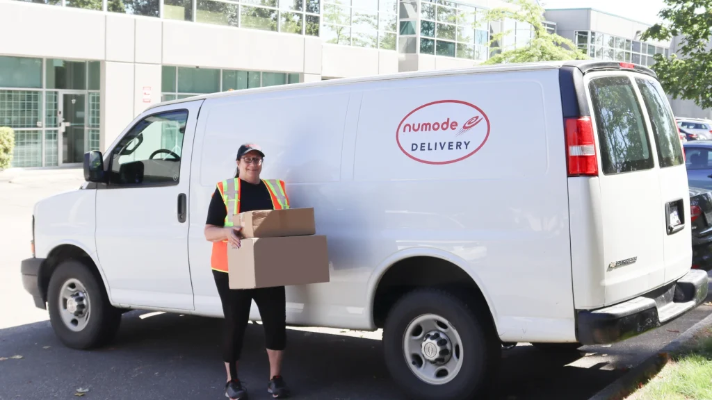 One of our Vancouver Couriers holding packages in front of one of our vans